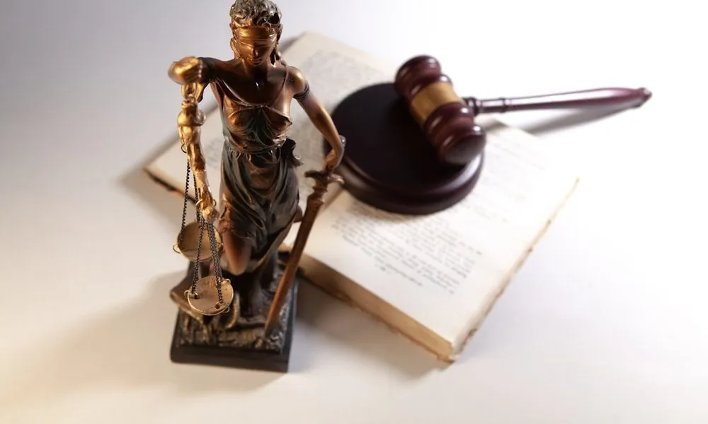 Consulente del PM e consulente di parte: statua della giustizia, martelletto e codice